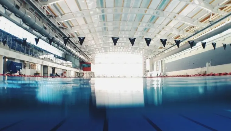 A long indoor training pool under a bright roof
