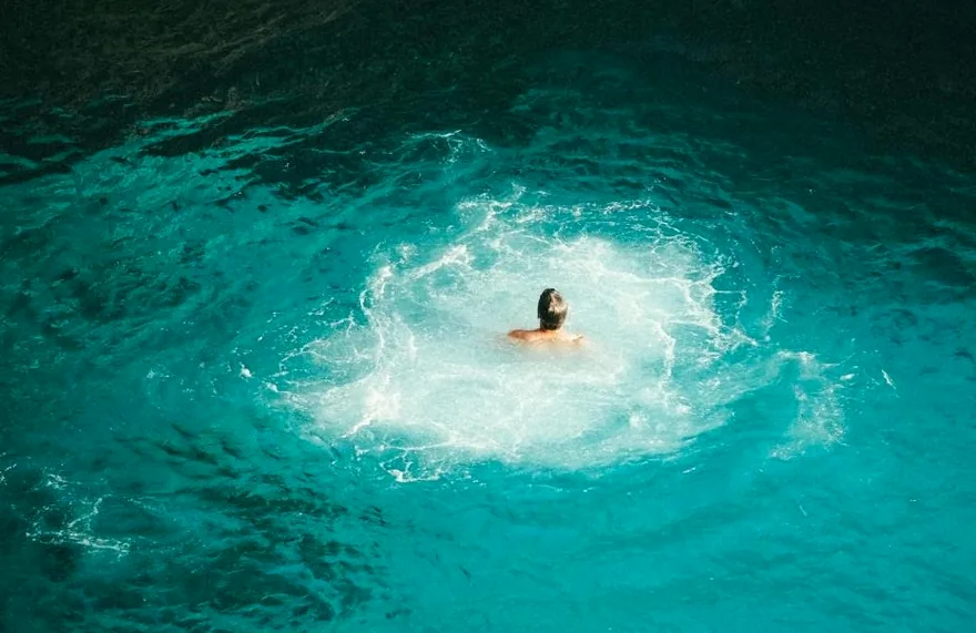 A swimmer diving into clear turquoise water