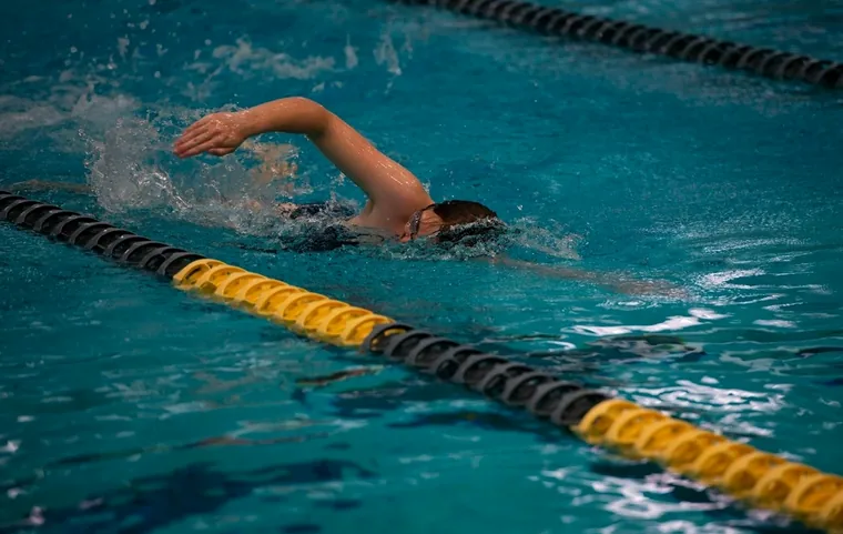 A swimmer doing front crawl beside a lane rope